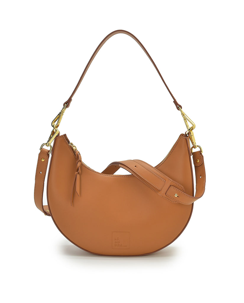 Bolso de hombro multiposición con forma de media luna de piel color camel Leandra. made in Spain